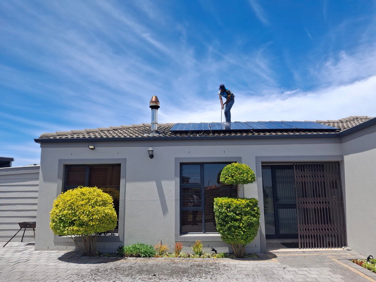 Technicien entretenant des panneaux photovoltaïques sur un toit