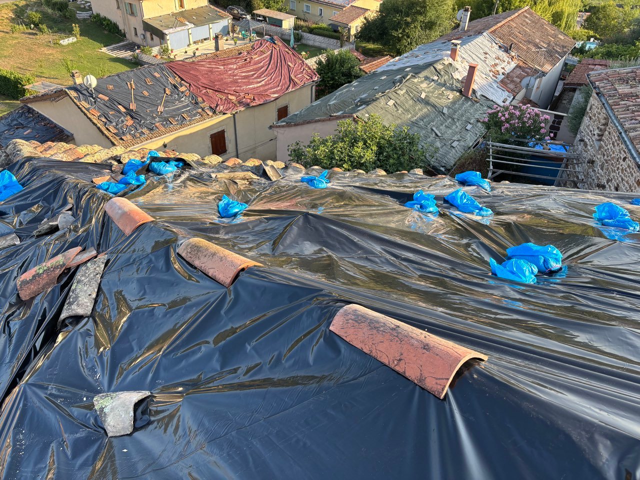 Vue aérienne de plusieurs toitures bâchées suite à la grêle
