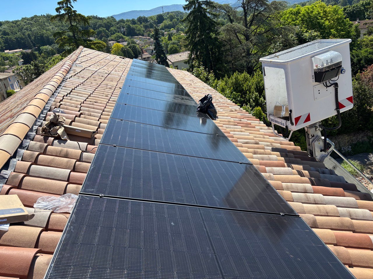 Large toiture entièrement couverte de panneaux photovoltaïques, sous un grand ciel bleu