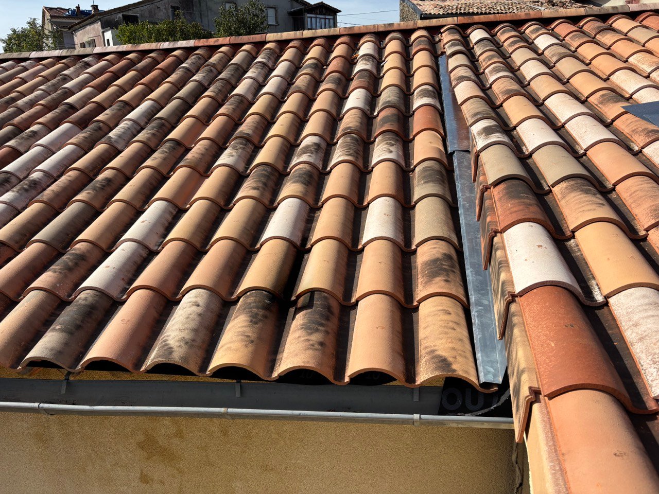 Détail de gouttière et faîtage sur une toiture en tuiles